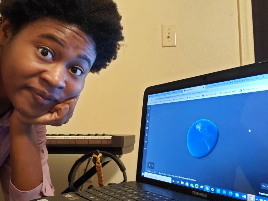 Picture of Desiree Robinson with Toshiba laptop screen open to Google Earth site.